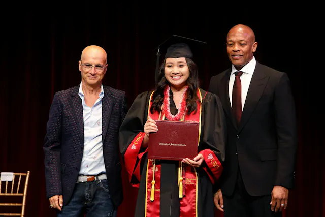 Jimmy Iovine and Andre "Dr. Dre" Young standing with student at a USC Iovine and Young Academy graduation ceremony